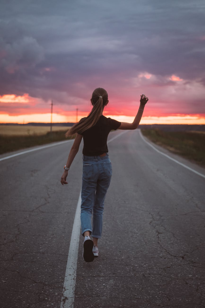 skinny teen walking on sunset road